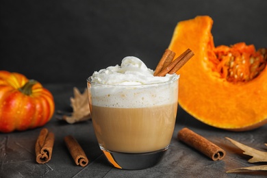 Photo of Composition with pumpkin spice latte in glass on table