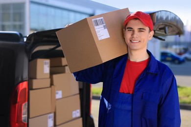 Courier with parcel near delivery van outdoors, space for text