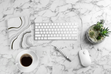 Flat lay composition with mouse and keyboard on white marble table