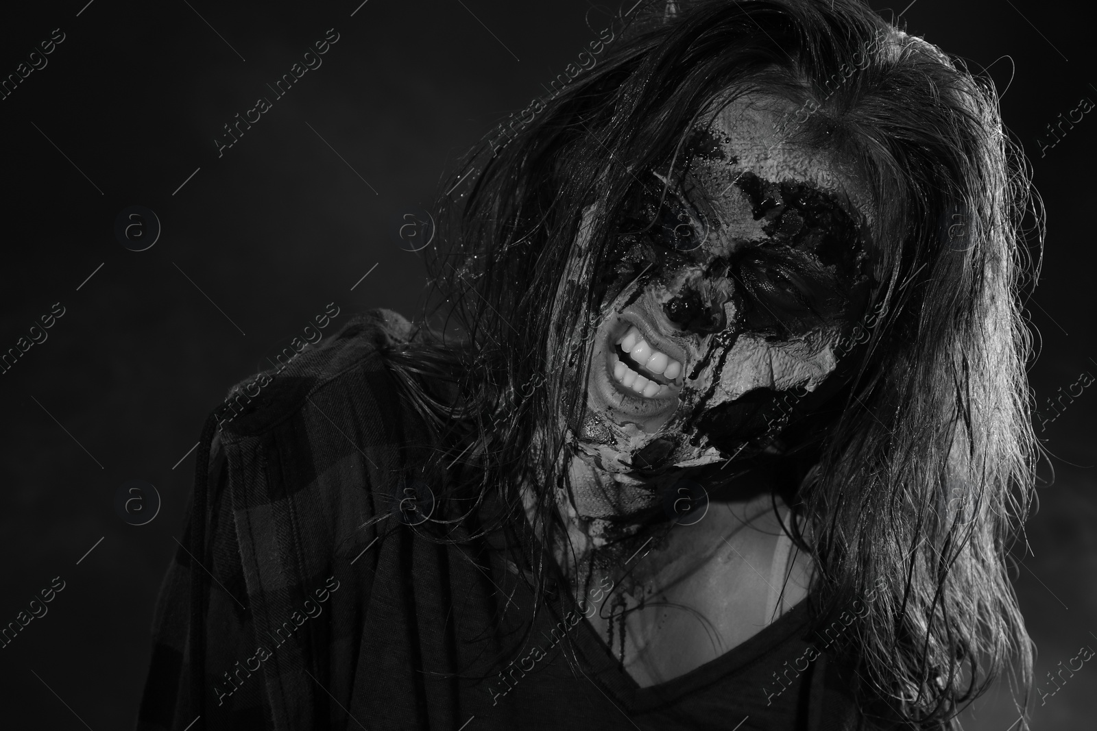 Photo of Scary zombie on dark background, black and white effect. Halloween monster