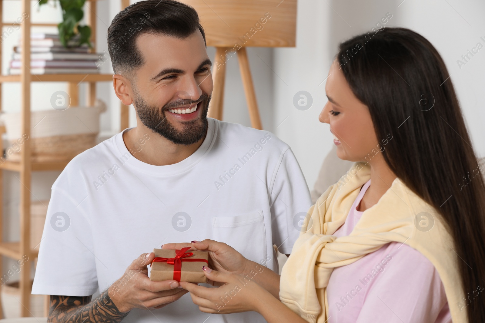 Photo of Lovely couple with beautiful gift at home