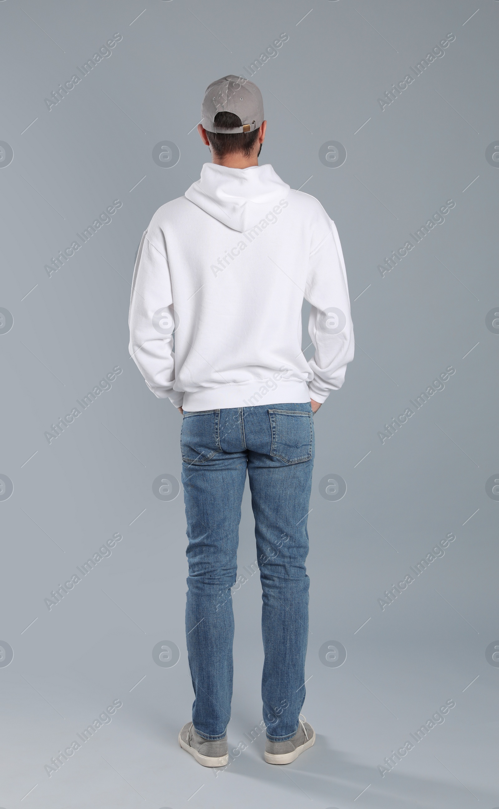 Photo of Young man in sweater on grey background. Mock up for design