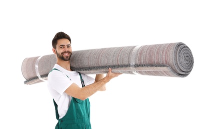 Young worker carrying rolled carpet isolated on white. Moving service