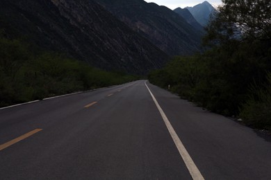 Beautiful view of empty asphalt highway near mountains outdoors. Road trip