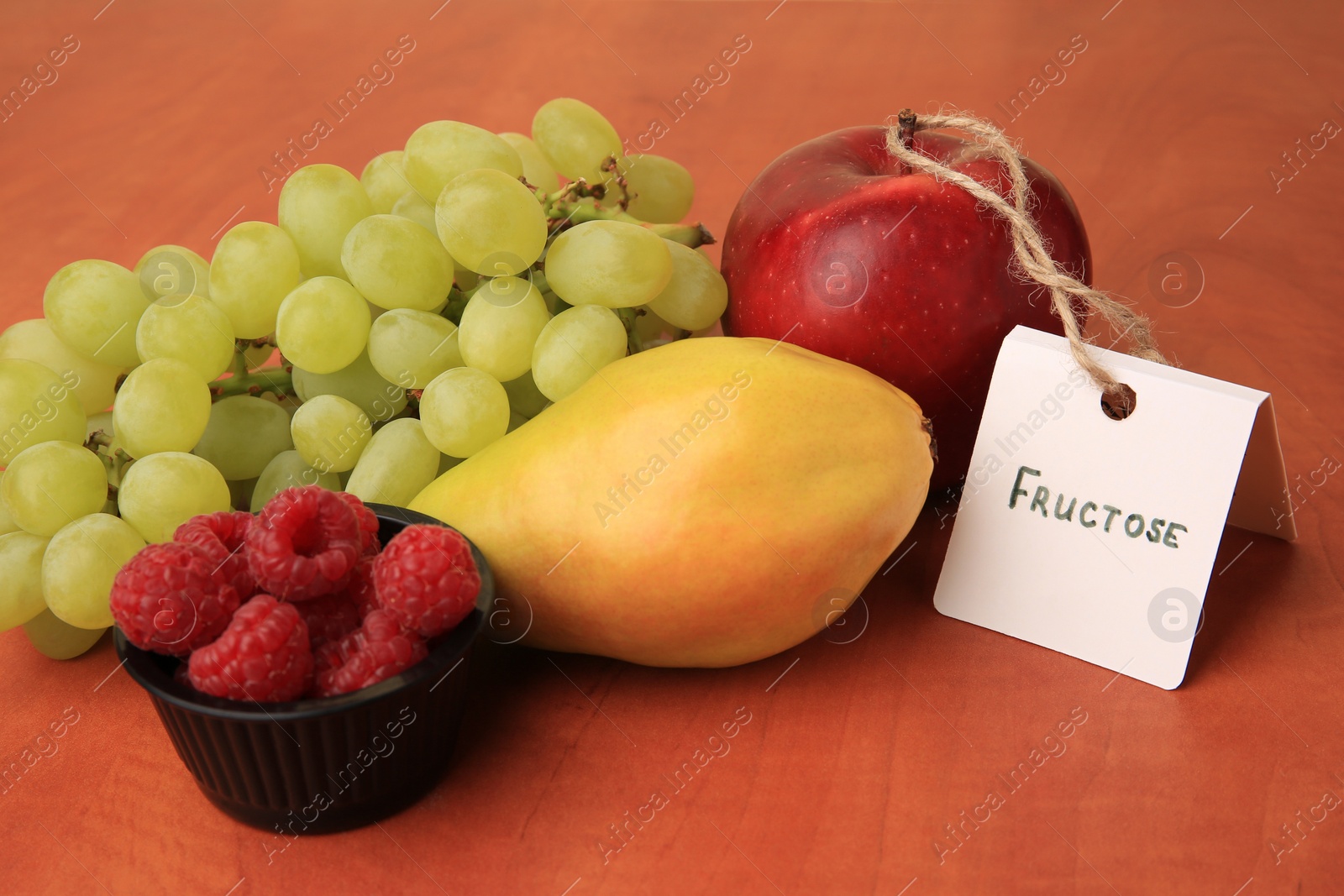 Photo of Card with word Fructose, delicious ripe fruits and raspberries on wooden table