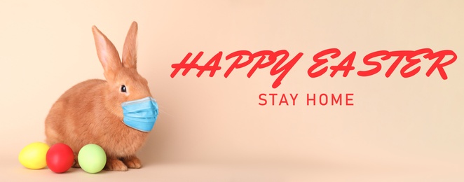 Image of Text Happy Easter Stay Home and cute bunny in protective mask on beige background, banner design. Holiday during Covid-19 pandemic