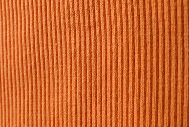 Texture of knitted orange fabric as background, closeup