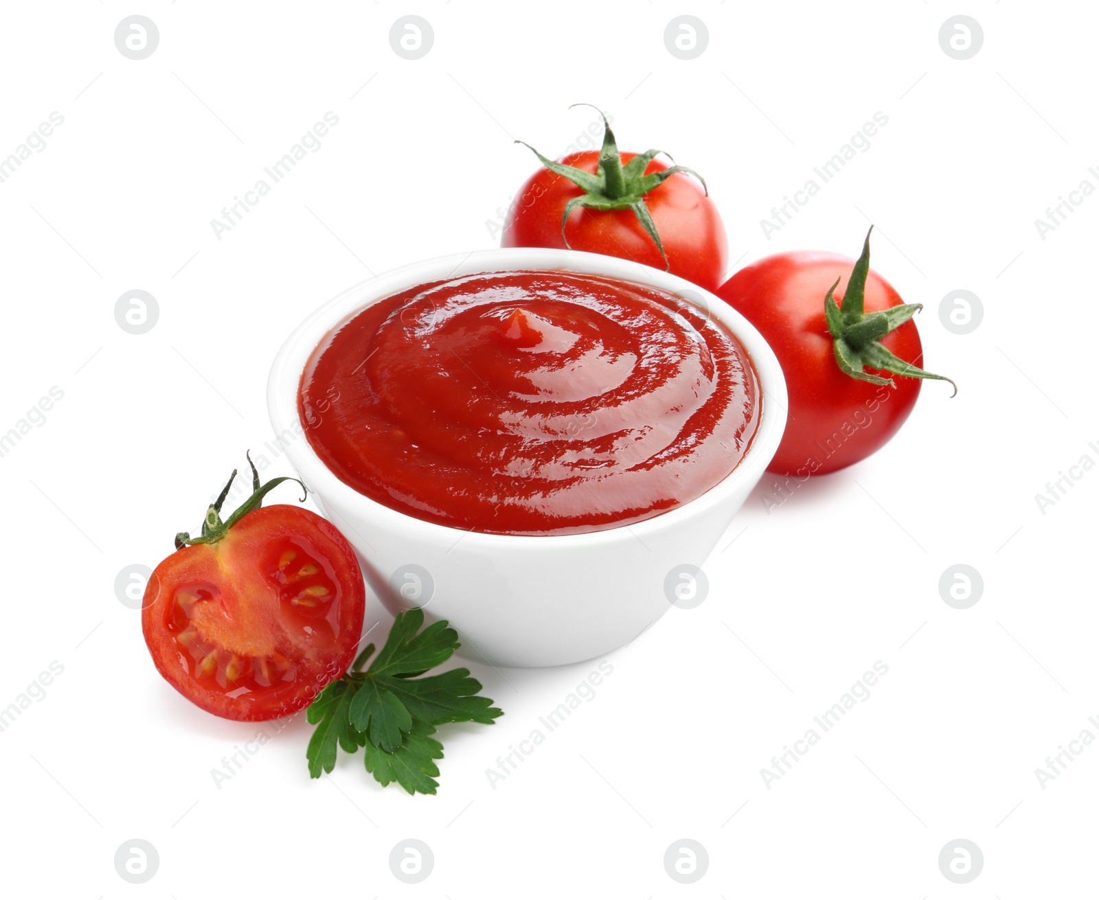 Photo of Tasty ketchup in bowl, parsley and fresh tomatoes isolated on white