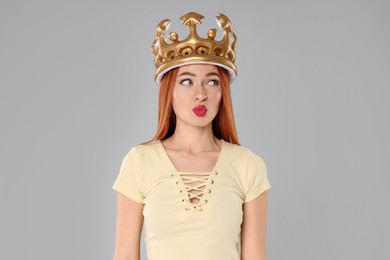 Photo of Beautiful young woman with inflatable crown on light grey background