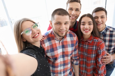 Happy friends taking selfie indoors