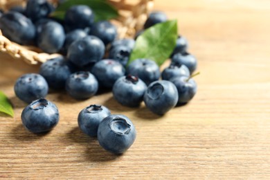 Fresh tasty blueberries on wooden table, closeup. Space for text