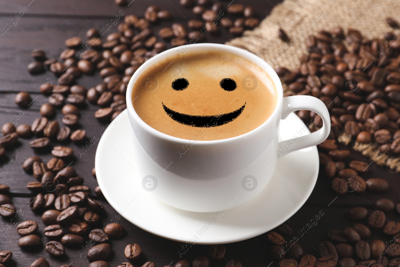 Image of Cup of hot aromatic coffee and roasted beans on wooden table. Good morning