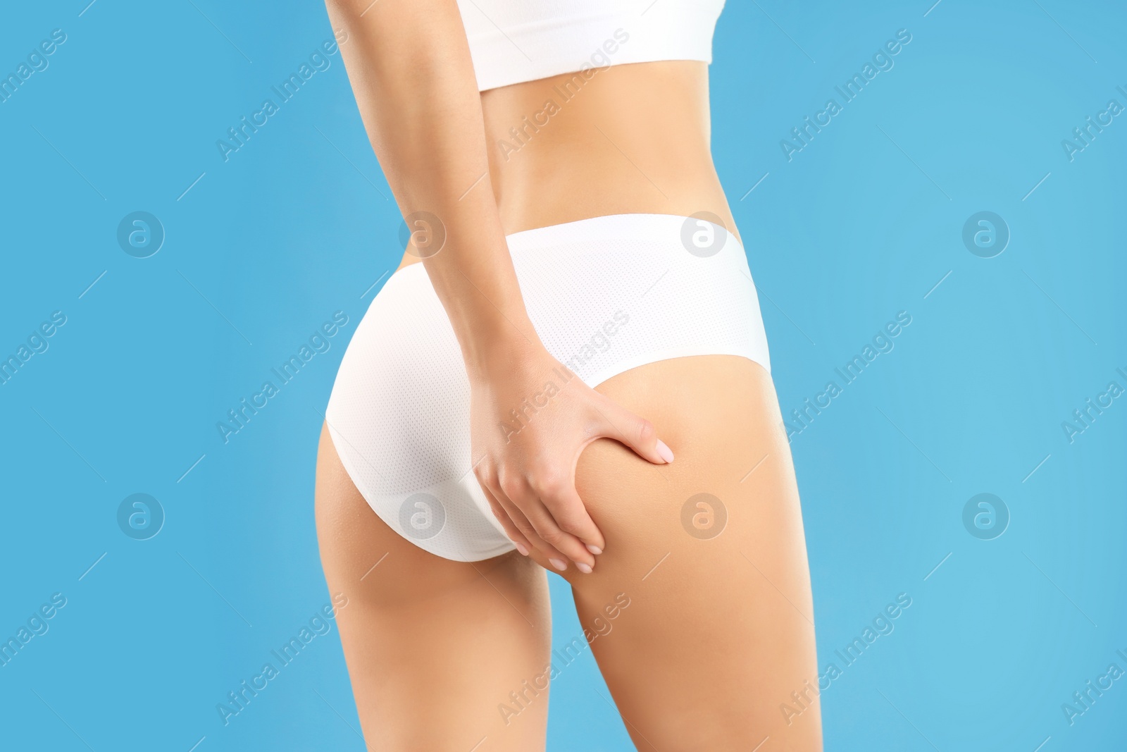 Photo of Closeup view of slim woman in underwear on color background. Cellulite problem concept