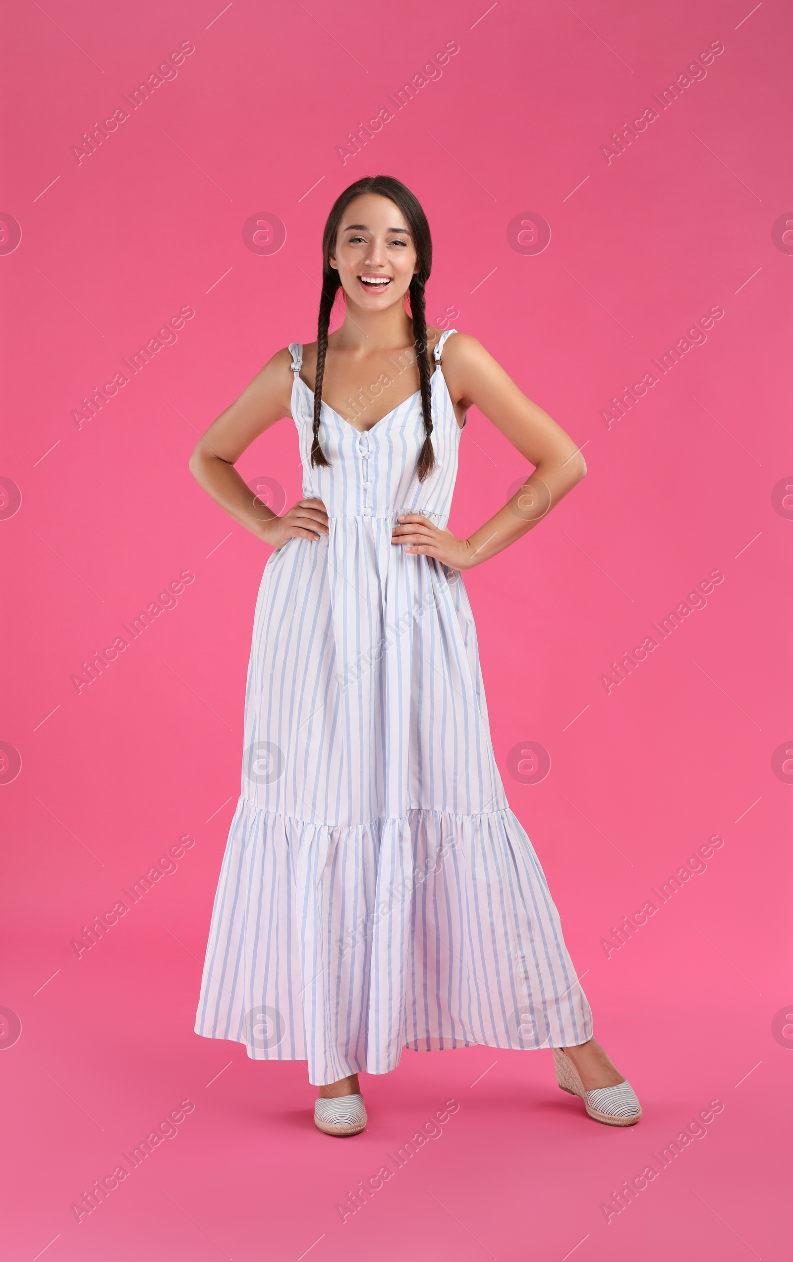 Photo of Young woman wearing stylish dress on pink background