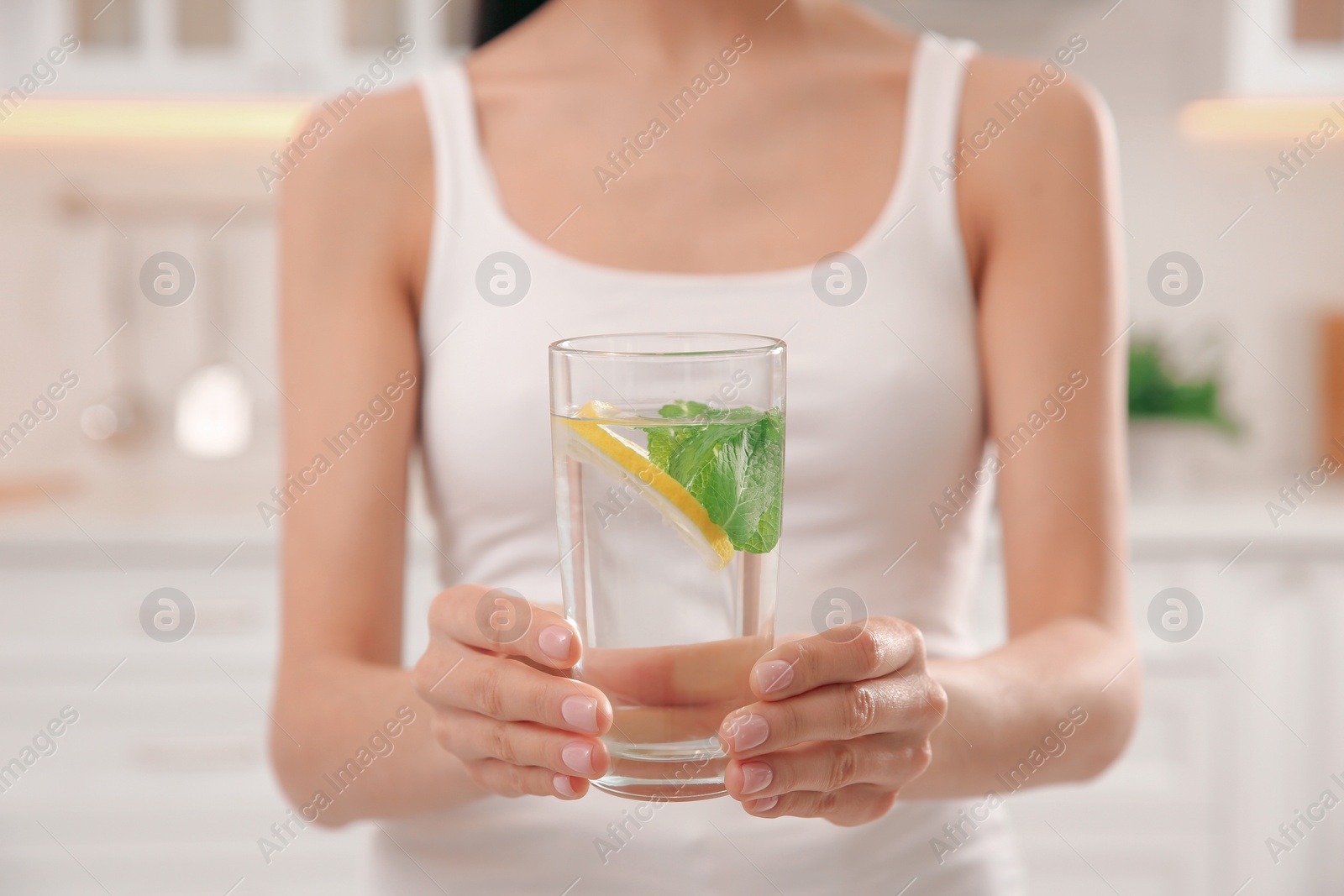 Photo of Young woman with glass of fresh lemonade at home, closeup