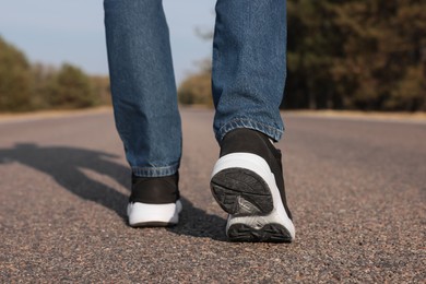 Photo of Man going along road, closeup of legs