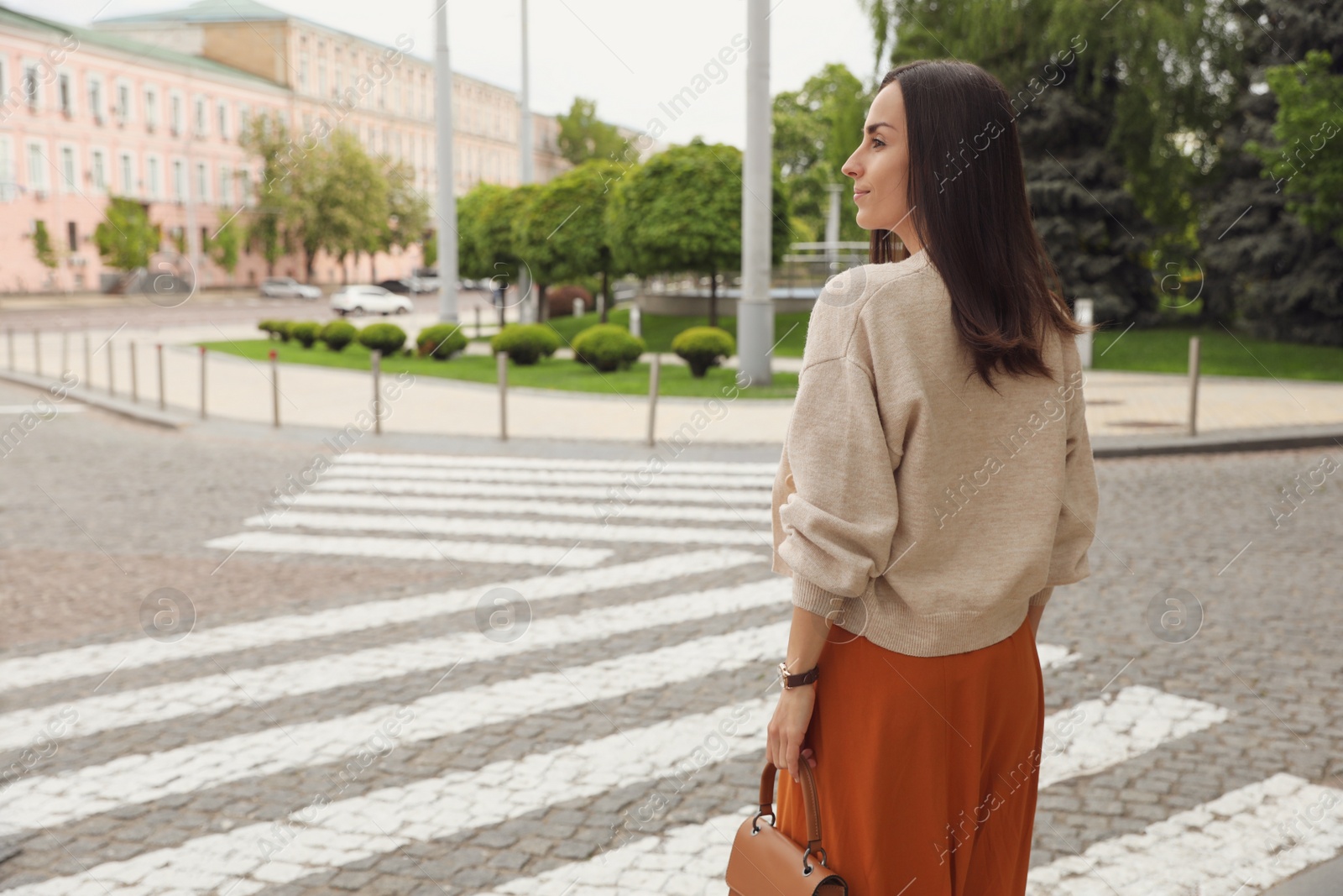 Photo of Young woman crossing street. Traffic rules and regulations