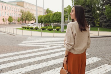 Photo of Young woman crossing street. Traffic rules and regulations