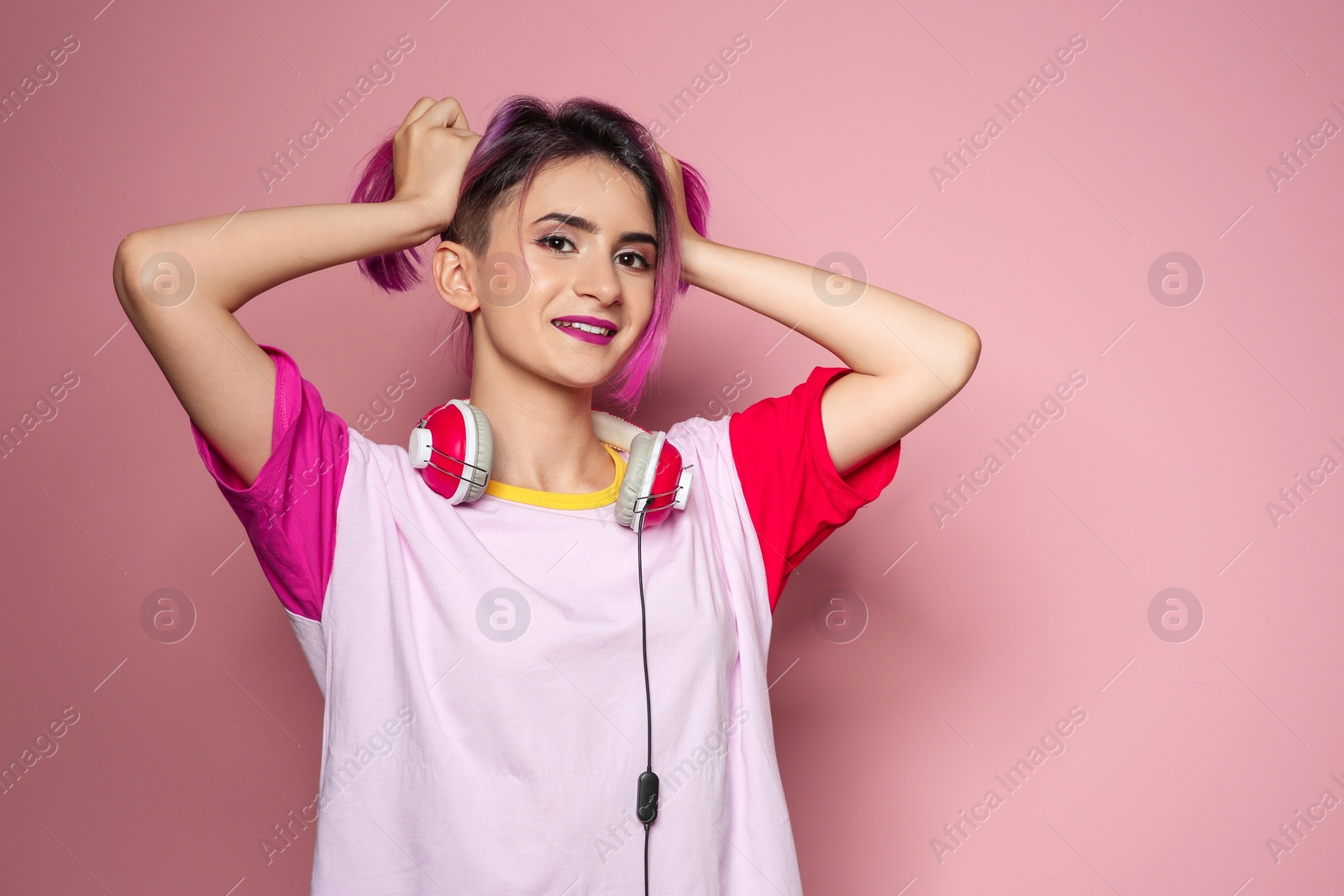 Photo of Young woman with trendy hairstyle and headphones against color background