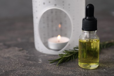 Photo of Aroma lamp and coniferous essential oil on grey table, closeup. Space for text