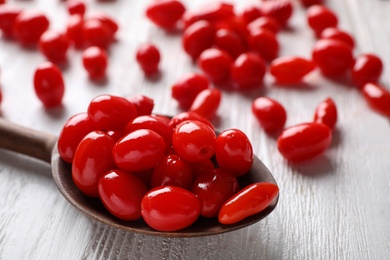 Fresh ripe goji berries in spoon on white wooden table