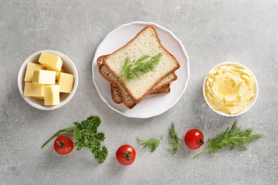 Flat lay composition with bread and butter on grey background