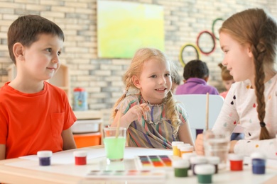 Cute little children painting at table indoors. Learning by playing