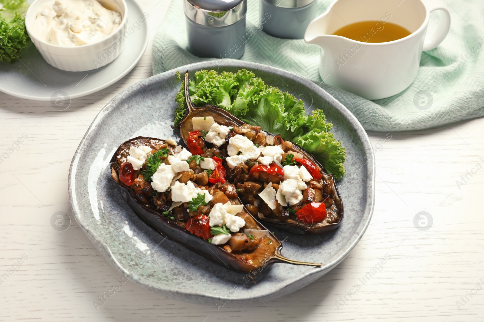 Photo of Plate with tasty stuffed eggplants on light table