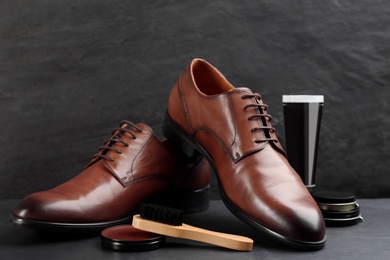 Photo of Shoe care accessories and footwear on black background