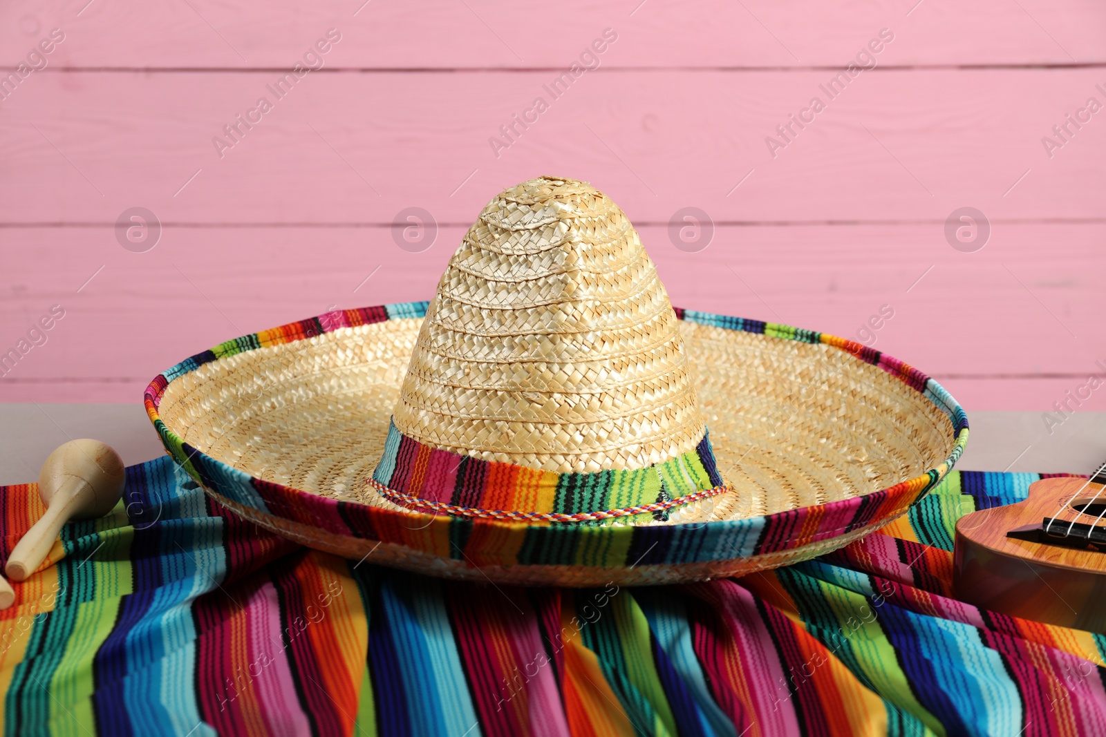 Photo of Mexican sombrero hat and poncho on table