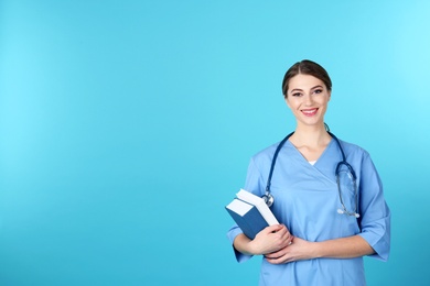 Young medical student with books on color background. Space for text