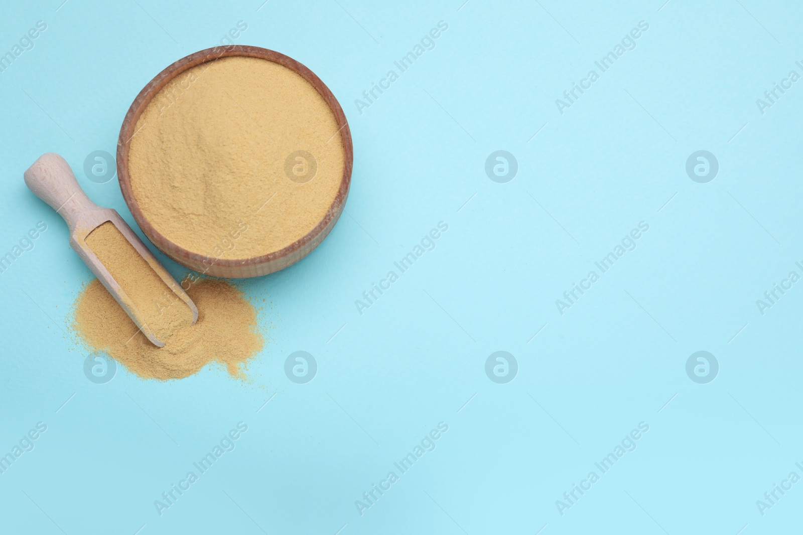 Photo of Beer yeast powder on light blue background, flat lay. Space for text