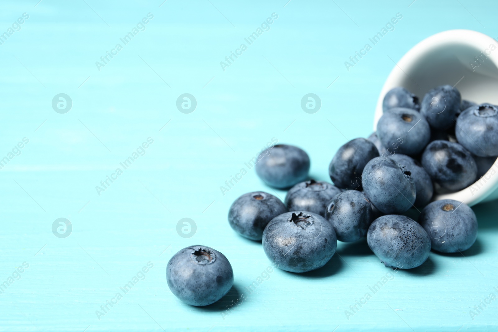 Photo of Juicy and fresh blueberries on color table. Space for text