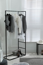 Rack with stylish women's clothes in dressing room. Interior design