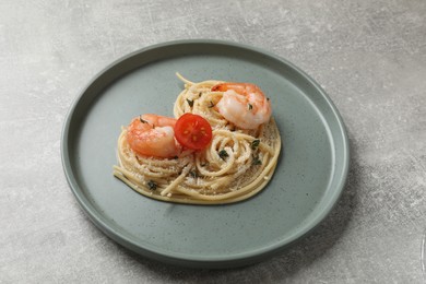 Photo of Heart made of tasty spaghetti, tomato, shrimps and cheese on light grey table