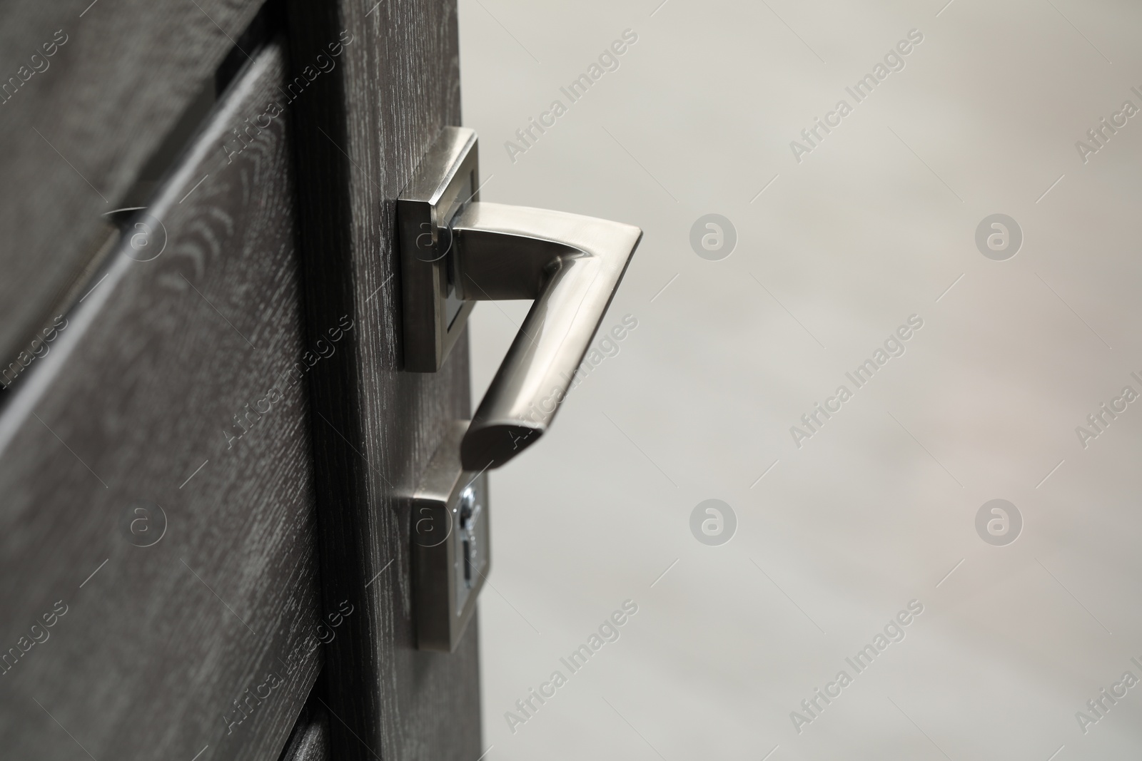 Photo of Open wooden door with metal handle, closeup