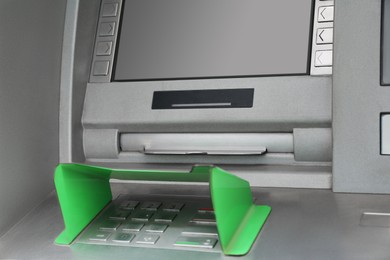Photo of Modern automated cash machine with screen and keypad