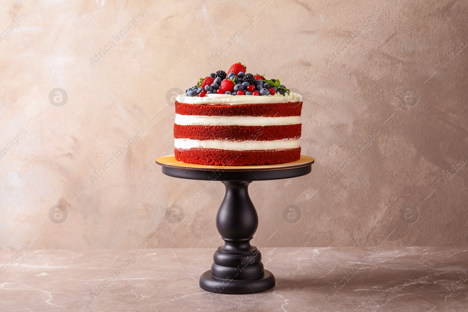 Photo of Stand with delicious homemade red velvet cake on color background