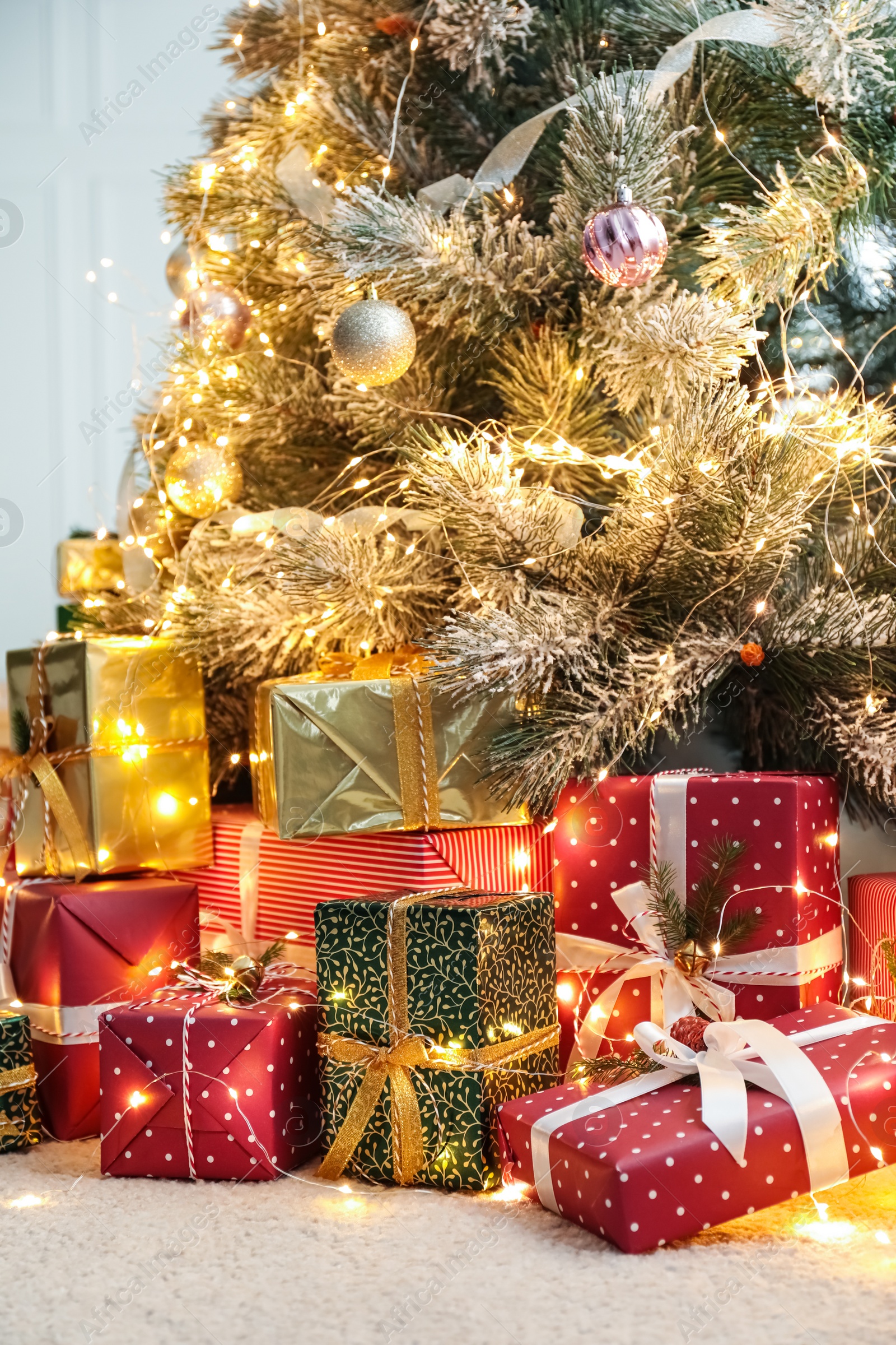 Photo of Many different gifts under Christmas tree indoors