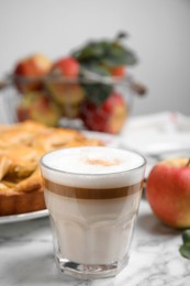 Glass of coffee and traditional apple pie on white marble table