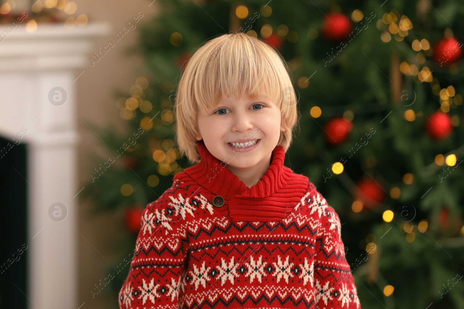 Photo of Portrait of little child in sweater at home. Christmas celebration