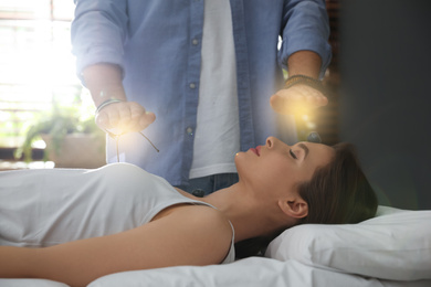Photo of Young woman during crystal healing session in therapy room