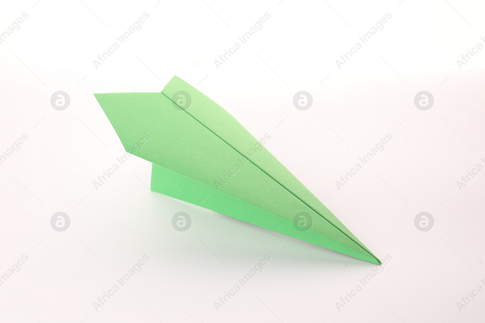 Photo of Handmade green paper plane isolated on white