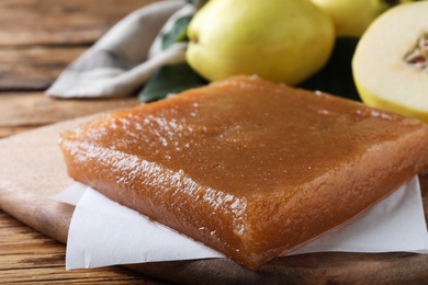 Photo of Delicious quince paste on wooden table, closeup