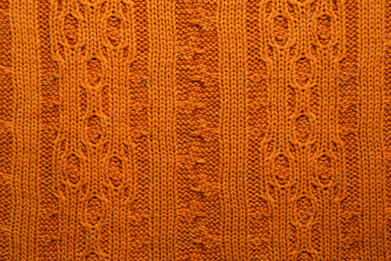 Photo of Beautiful orange knitted fabric as background, top view