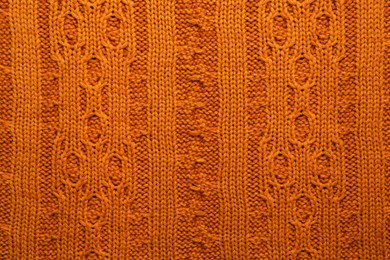 Photo of Beautiful orange knitted fabric as background, top view