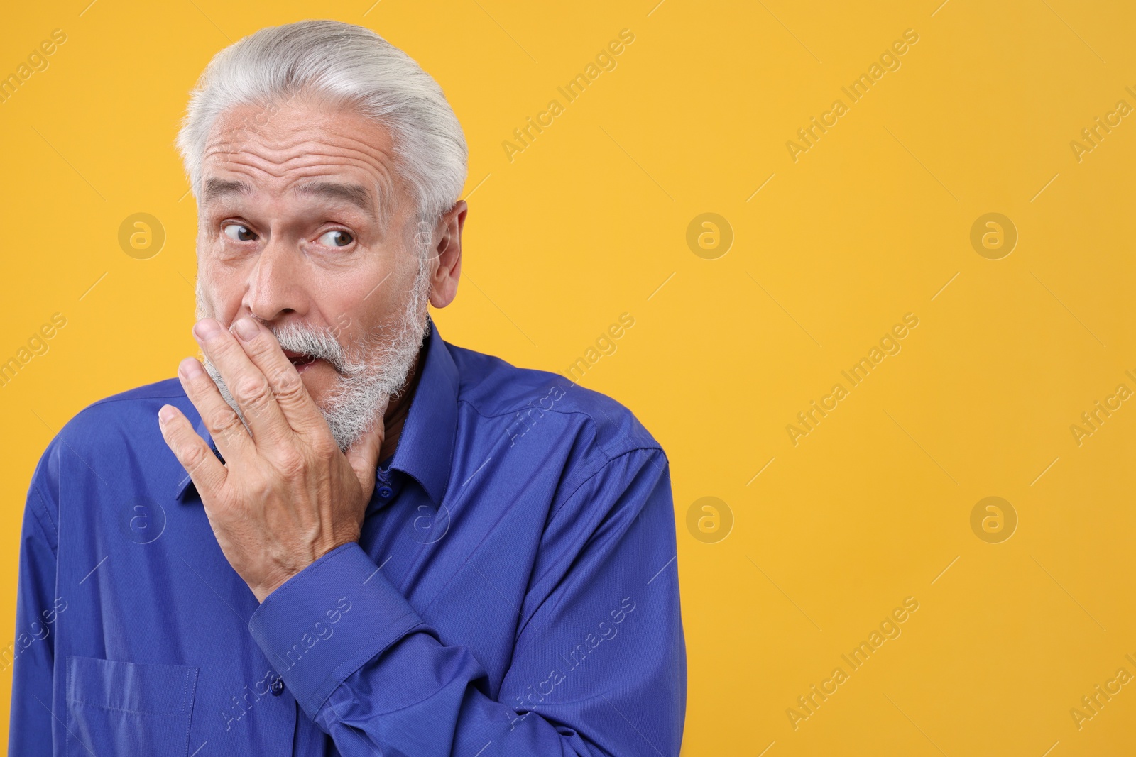 Photo of Embarrassed senior man on orange background. Space for text