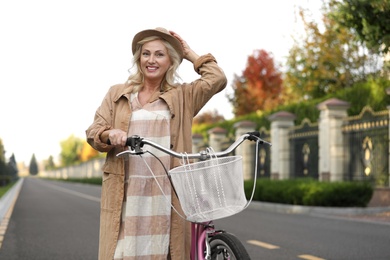 Photo of Mature woman with bicycle outdoors. Active lifestyle