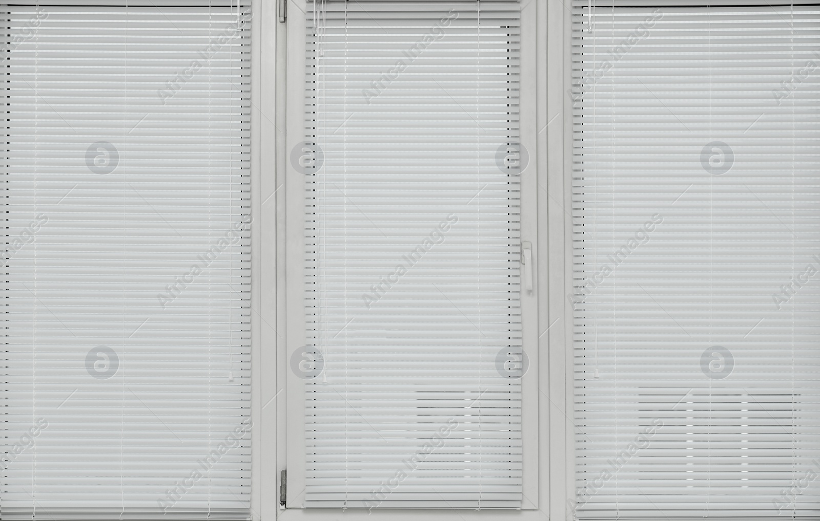 Photo of Stylish window with horizontal blinds in room