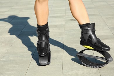 Woman in kangoo jumping boots outdoors on sunny day, closeup